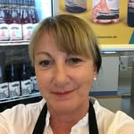 Professional woman smiling in front of a display of gourmet products